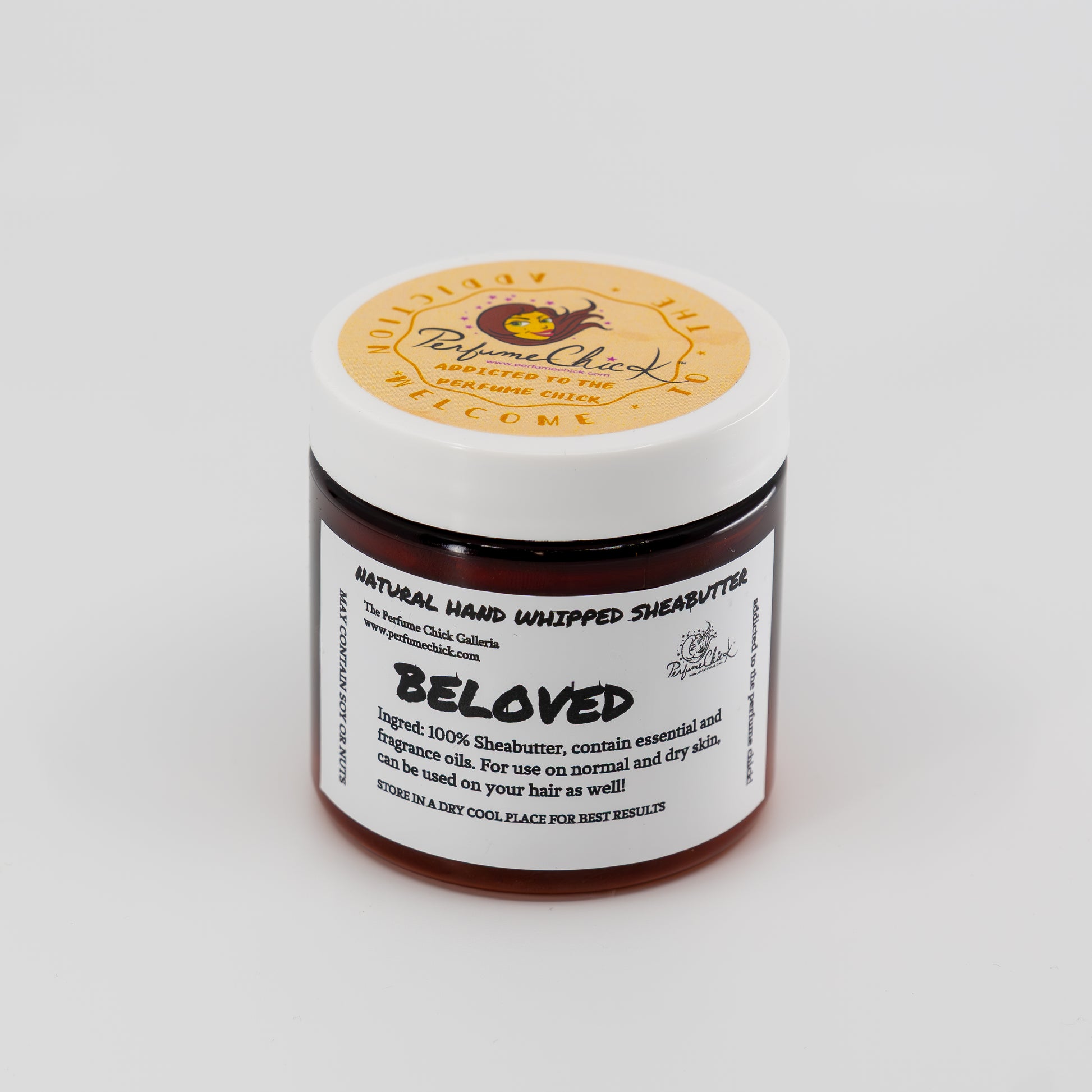 Jar of natural hand whipped shea butter with a white label on a light gray background