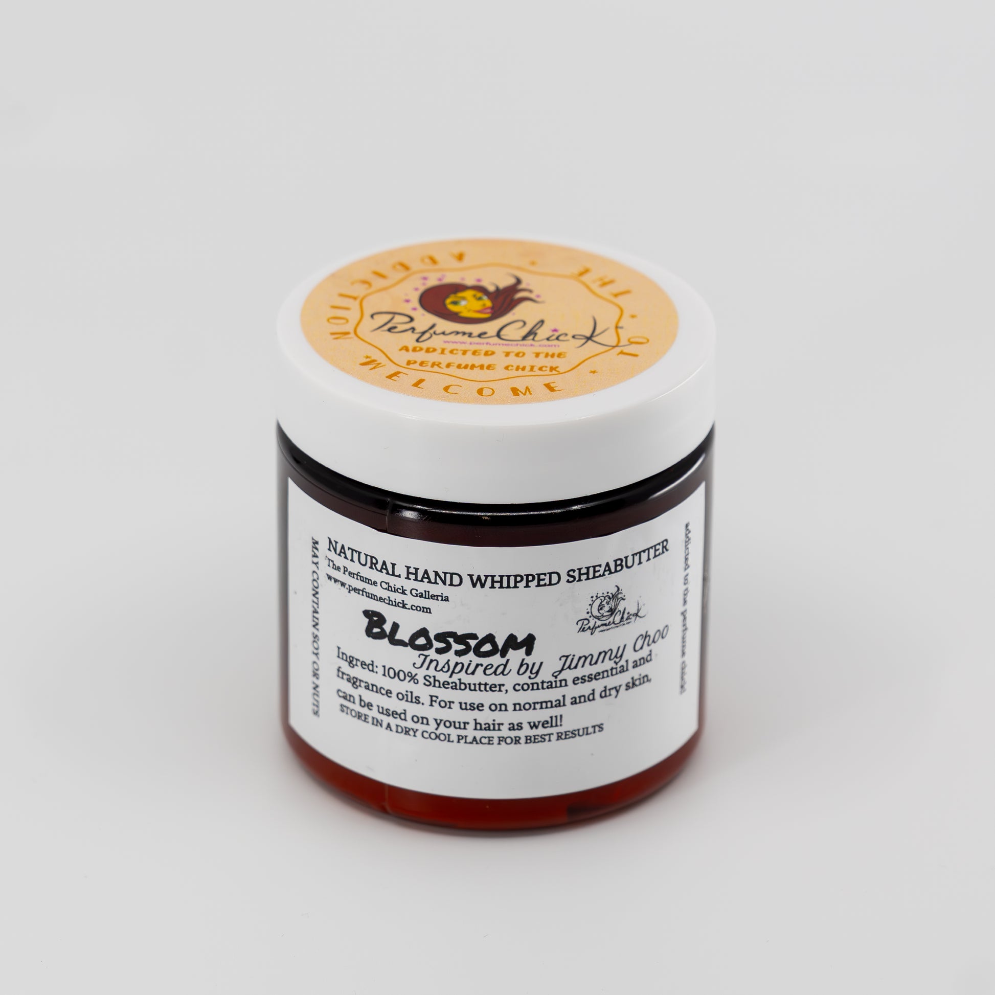 Jar of natural hand whipped shea butter with a visible label on a white background