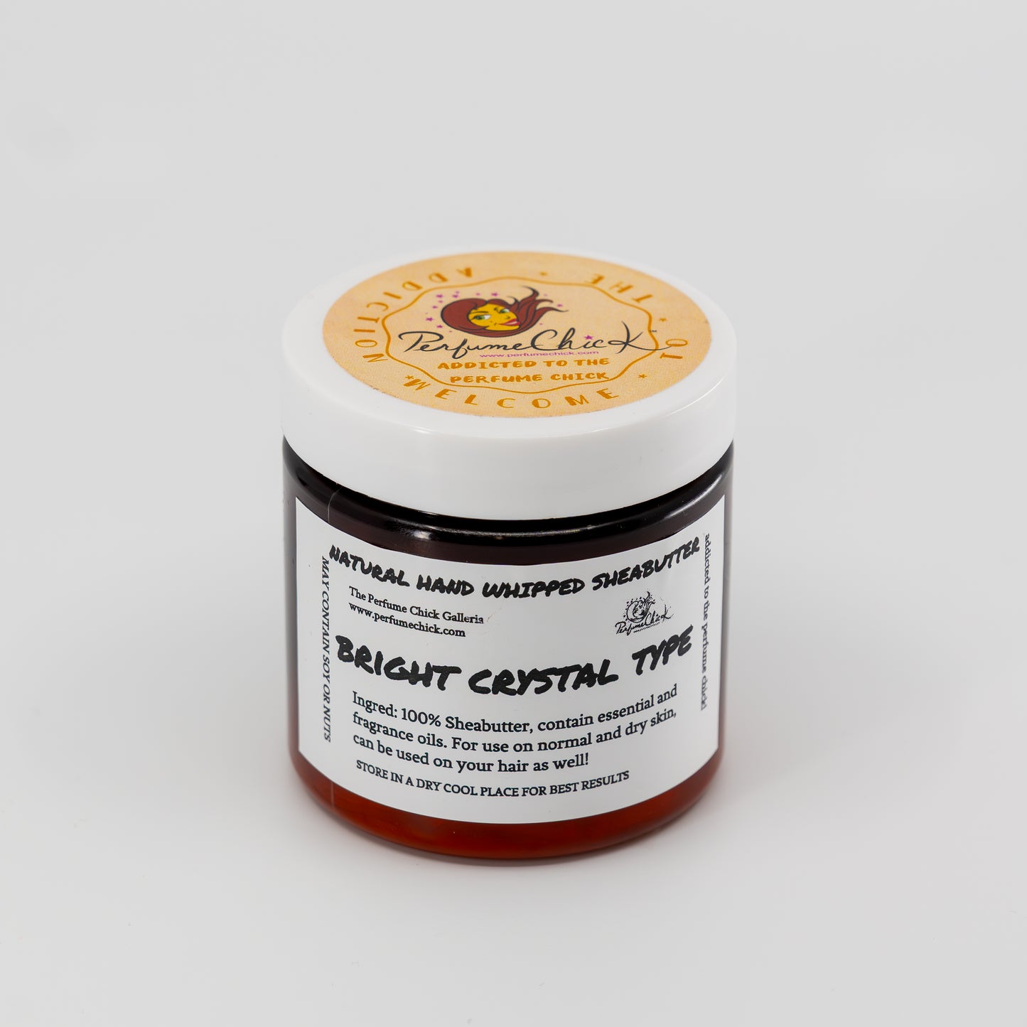 Jar of natural hand whipped shea butter with a label on a white background